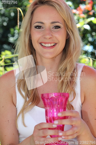 Image of Smiling young woman holding a vase