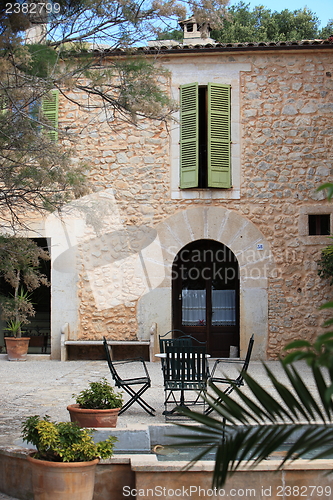 Image of Table and chairs in front of a stone building