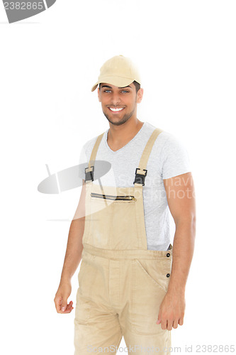 Image of Smiling handsome man in dungarees and cap