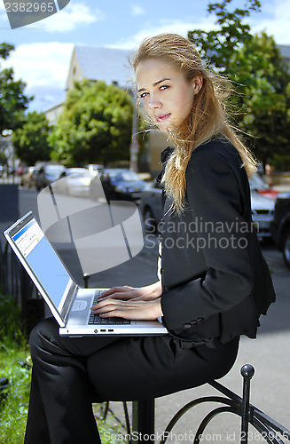 Image of happy businesswoman with laptop computer b