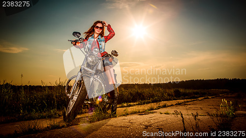 Image of Biker girl sitting on motorcycle