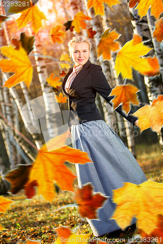 Image of Woman and autumn leaves in the park.