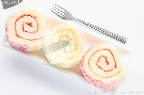 Image of Dish of colorful jam roll cakes with fork