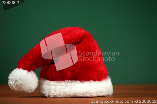 Image of Red Santa Hat With Copy Space on Green and Wood Background