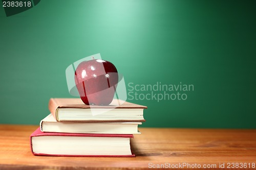 Image of Apple Plus Stack of Books on A Desk for Back to School