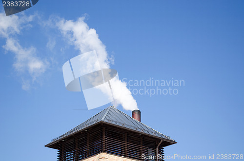 Image of modern tin roof smoke rise chimney pipe blue sky 