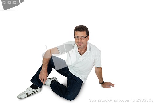 Image of attractive healthy adult man sitting on floor with jeans isolated