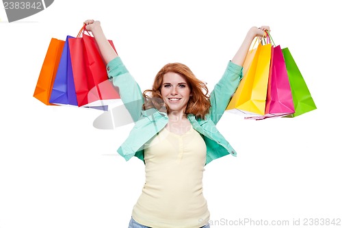 Image of smiling young redhead girl with colorful shoppingbags 