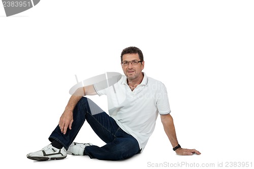 Image of attractive healthy adult man sitting on floor with jeans isolated