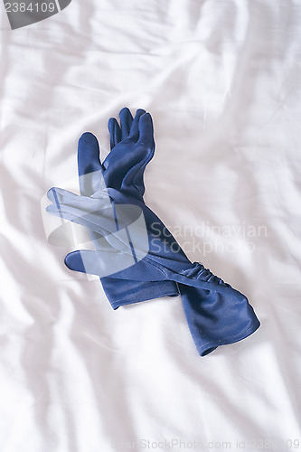 Image of blue gloves on bed