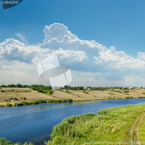 Image of view to river with reflections and blue cloudy sky