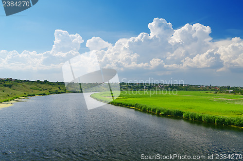 Image of cloudy sky and river with canes