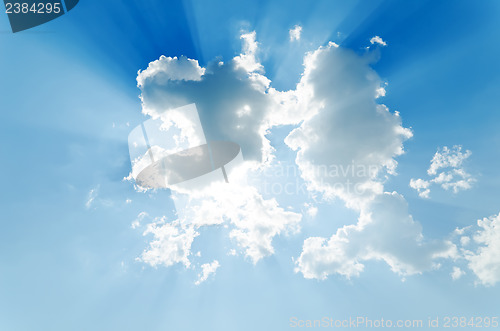 Image of clouds with sunrays on blue sky