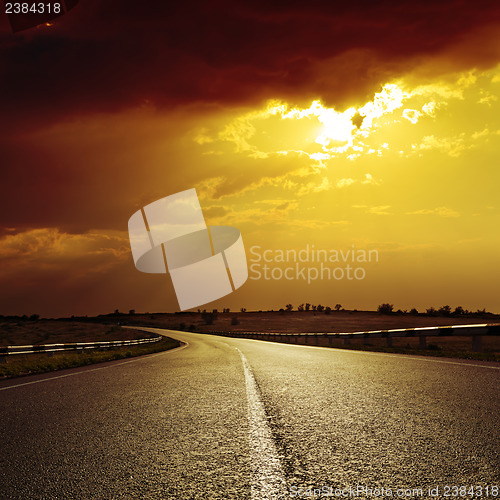 Image of asphalt road to dramatic sunset