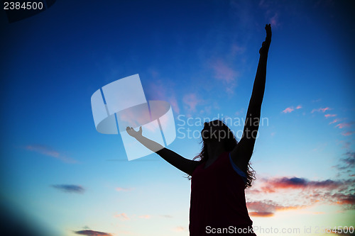 Image of Woman staying with raised hands