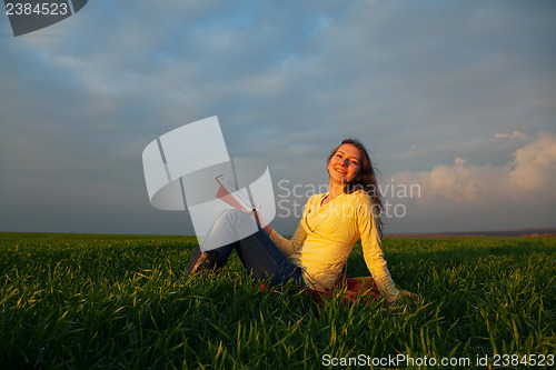 Image of Teen girl reading book outdoors