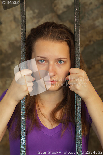 Image of Young woman behind the bars