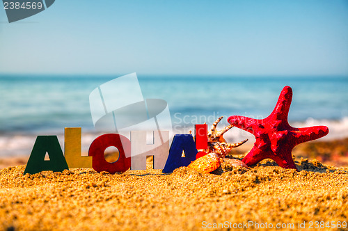 Image of Wooden colorful word 'Aloha' on the sand