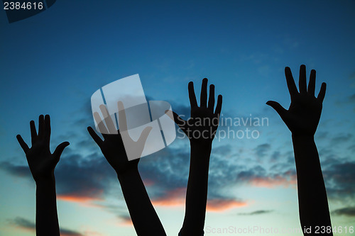 Image of Four raised hands