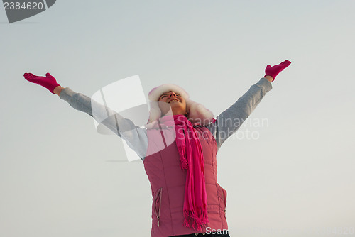 Image of Teen girl staying with raised hands