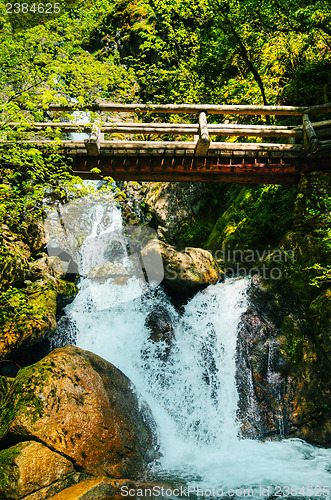 Image of Wooden bridge over waterfalls in the mountains
