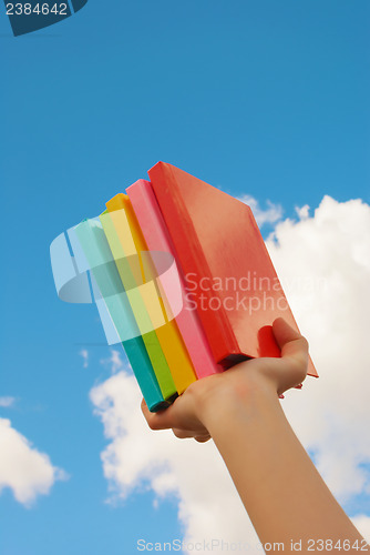 Image of Hands holding colorful hard cover books