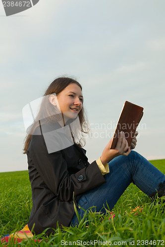 Image of Teen girl reading the Bible outdoors