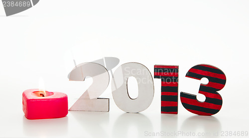 Image of Wooden 2013 year number with a burning candle