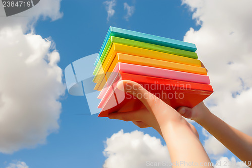 Image of Hands holding colorful hard cover books