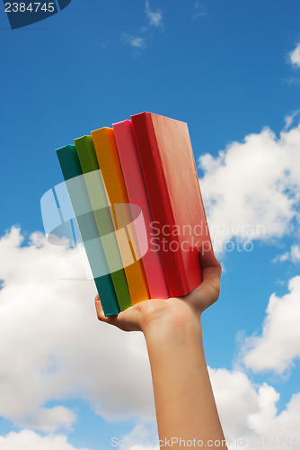 Image of Hands holding colorful hard cover books