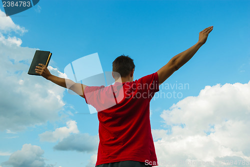 Image of Young man staying with raised hands