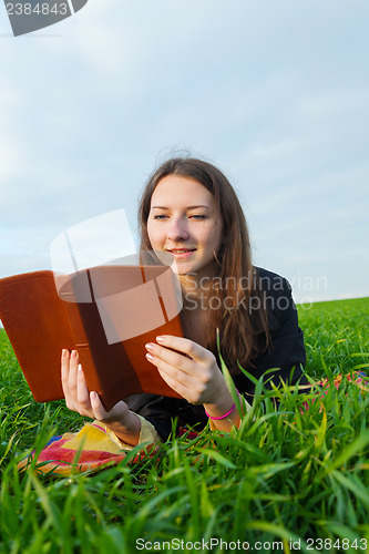 Image of Teen girl reading the Bible outdoors