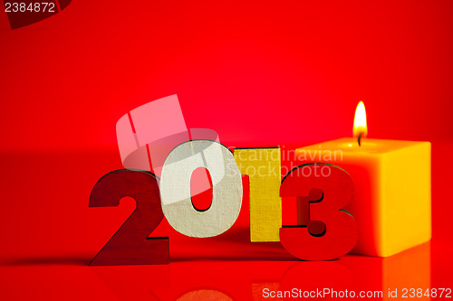 Image of Wooden 2013 year number with a burning candle