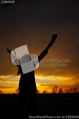 Image of Woman staying with raised hands
