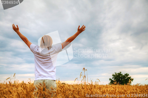 Image of Young man staying with raised hands