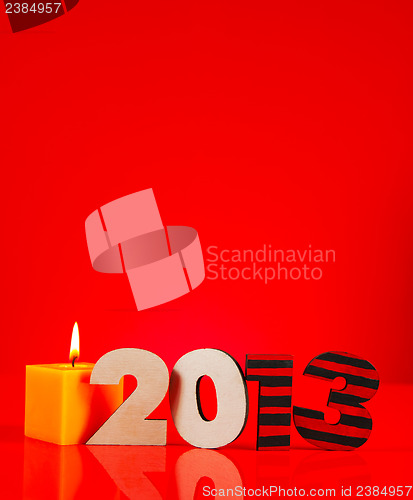Image of Wooden 2013 year number with a burning candle