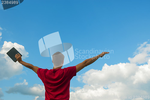 Image of Young man staying with raised hands