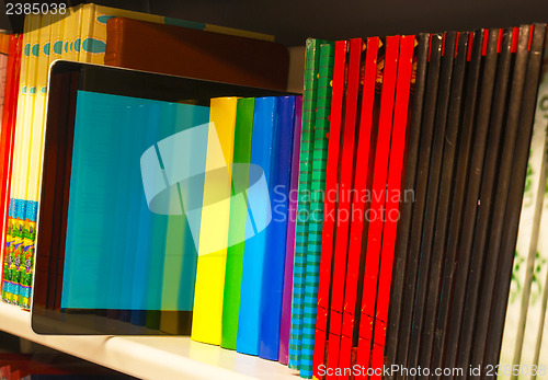 Image of Row of colorful books and electronic book reader