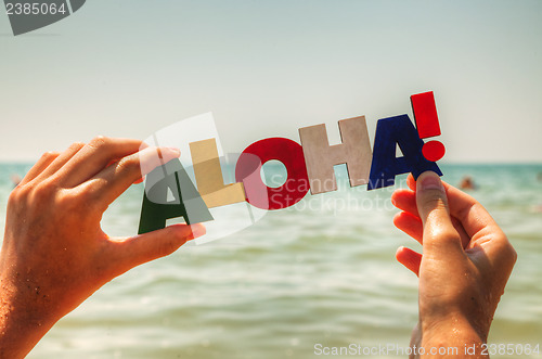 Image of Female's hand holding colorful word 'Aloha'