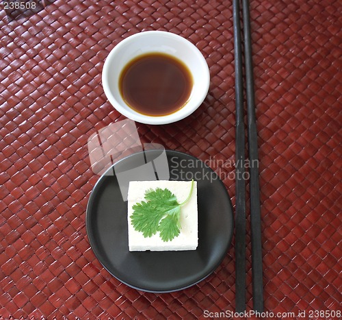 Image of tofu square on a round black dish