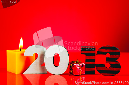 Image of Wooden 2013 year number with a burning candle