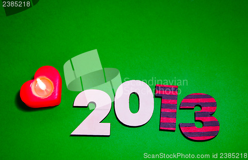 Image of Wooden 2013 year number with a burning candle