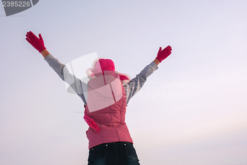 Image of Teen girl staying with raised hands