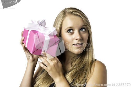 Image of Young blond girl listens to a gift