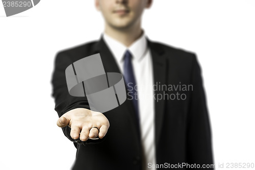 Image of Businessman in dark suit holds out his hand flat