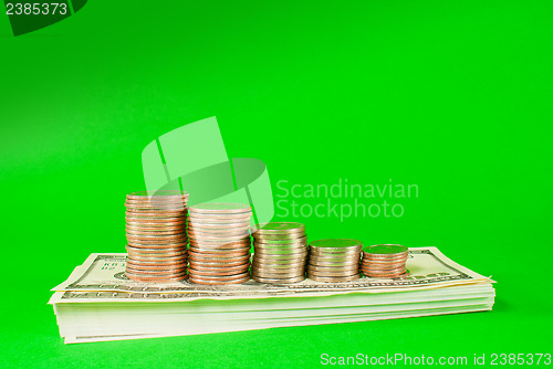 Image of Coins stacked in bars laying on stack of 100 dollar bills