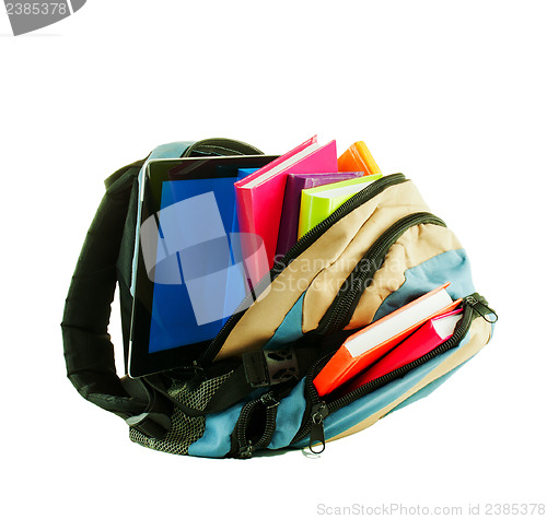 Image of Backpack with colorful books and tablet PC against white backgro