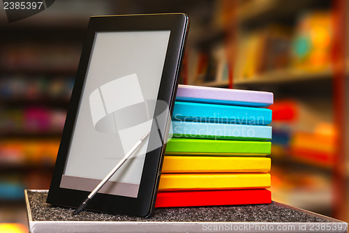 Image of Stack of colorful books with electronic book reader