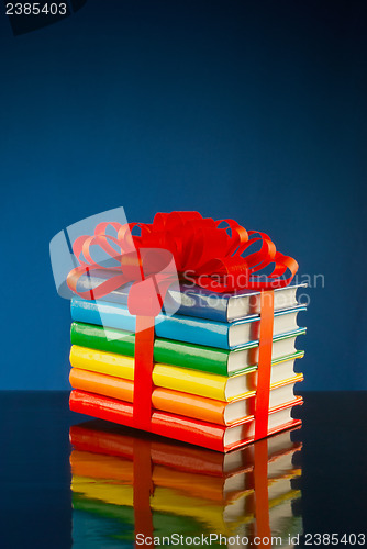 Image of Stack of colorful books tied up with red ribbon