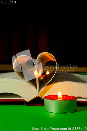 Image of Open book with burning candle